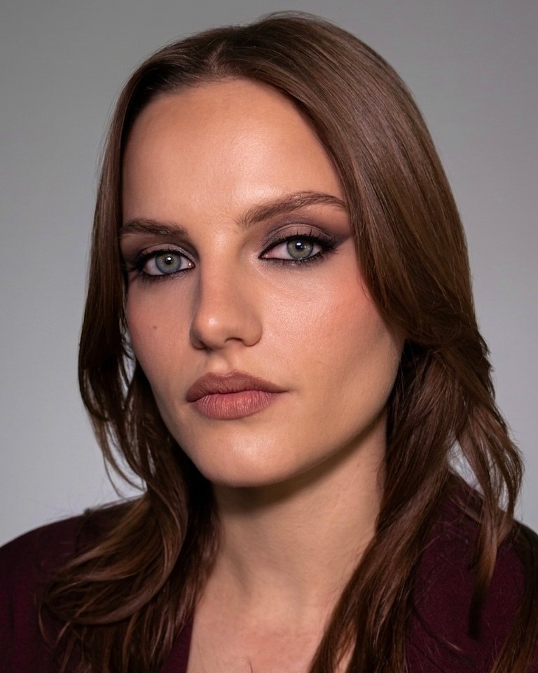 Makeup soft glam con smokey prugna sugli occhi, base luminosa e labbra nude
